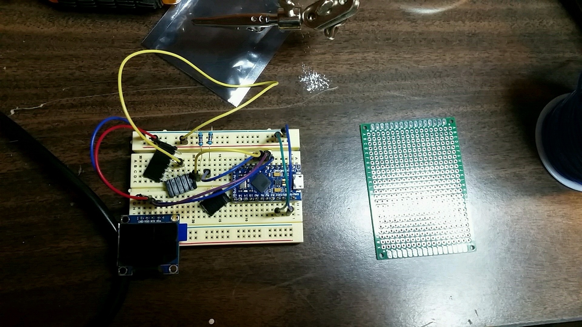 Image of breadboard next to circuitboard used for creating second prototype.